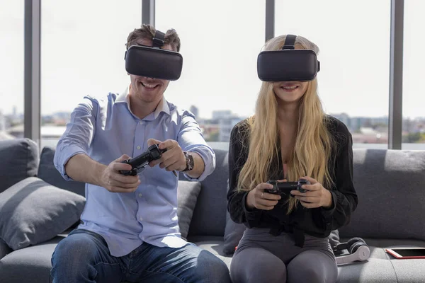 Young couple sitting on the floor at home. Portrait of wife and husband have fun playing video games with joystick and VR. stay at home.