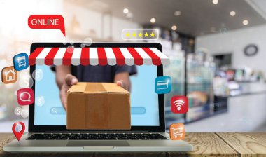Teslimatçı süpermarketteki bir masada dizüstü bilgisayardan paketler gönderiyor. Yeni normal ve sosyal mesafeler. E-ticaret, piyasa ve çevrimiçi alışveriş kavramı.