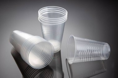 Yeni boş plastik bardaklar seti. Tek kullanımlık plastik atık. Kapat.