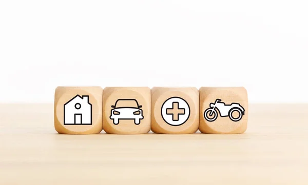 House, car, health and bike icons on wooden blocks Types of insurance concept. Copy space