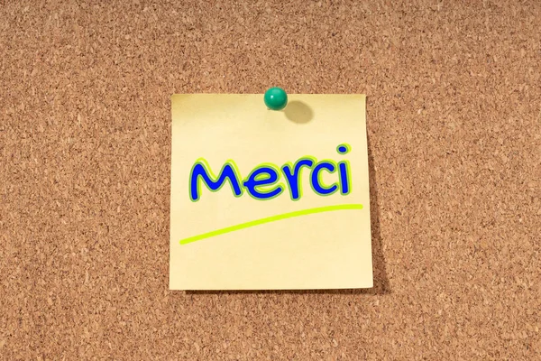 コルクボード上の黄色のノートにフランス語で感謝の言葉 — ストック写真