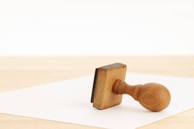 Antika kauçuk damgası ve tahta masanın üzerinde boş bir kağıt. Beyaz arka plan. Boşluğu kopyala