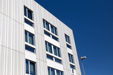 Modern apartment building with decorative grooved concrete facade. Copy space