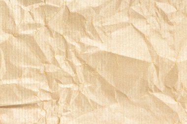 Crumpled Kraft paper texture background. Light golden brown color