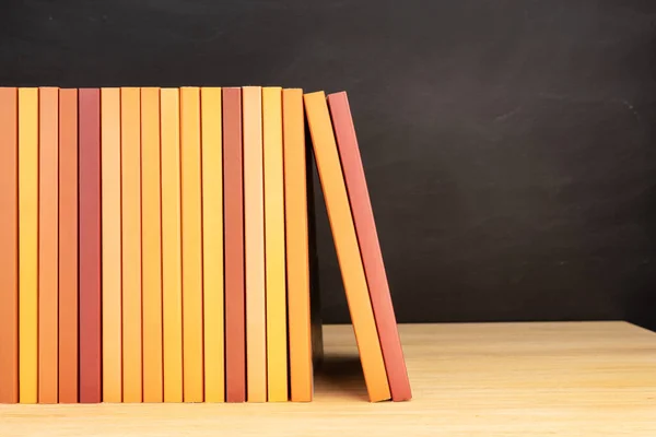 Grupo Libros Color Naranja Sobre Mesa Madera Estantes Pizarra Fondo — Foto de Stock