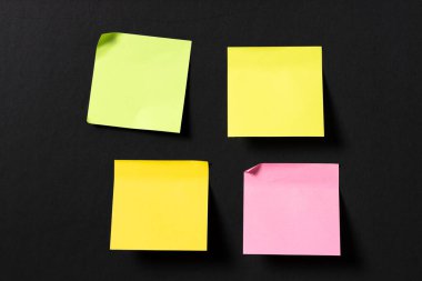 Siyah duvarda dört tane boş renkli yapışkan not var. Şablon maketi