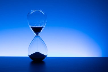 Kum saati, akan kum, zamanı, geri sayımı ve mavi ışıkta teslim süresini simgeliyor. Boşluğu kopyala