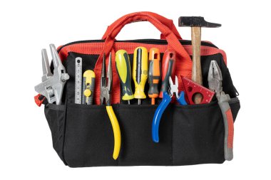 Beyaz arkaplanda izole edilmiş çeşitli el aletleri içeren kırmızı ve siyah kumaş alet çantası