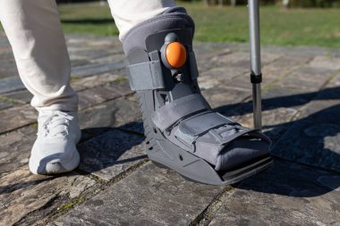 Koltuk değnekleriyle gezen birini kameraya çek. Bacağı dışarıda yaralanmış birini tedavi et.