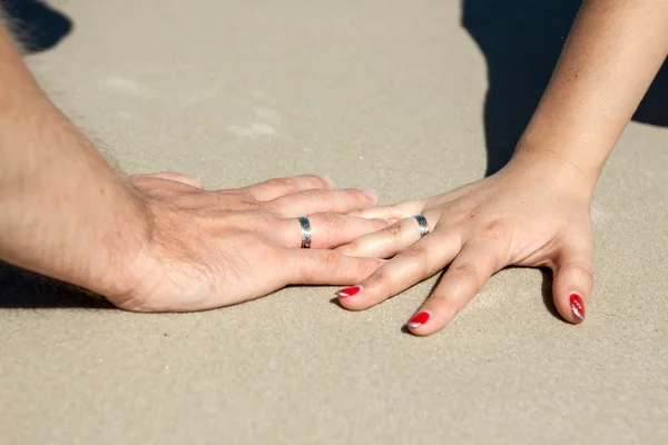 Snubní prsteny na prstech nevěsty a ženicha — Stock fotografie