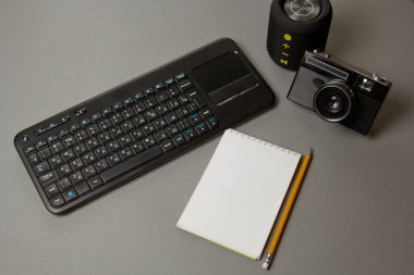 İş yeri blogcusu. Genel konuşma ve yazma metnine hazırlanmak için ayarlandı: klavye, defter, kalem, kamera, üst görünüm.