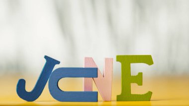 Çok renkli parlak ahşap harflerin yazıtları parlak sarı arkaplan fotokopi uzayında yatıyor. tatil kavramı.