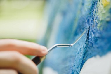 Avrupalı bir sanatçının eli yağlı boyaya bulanmış bir mastekhin tutuyor ve bir resim çiziyor. Van Gogh 'un sahte Starry gecesi. Arka plan bulanık. Yakın plan..