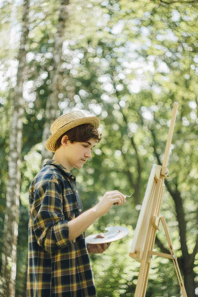 Joven Con Sombrero Paja Sienta Parque Frente Caballete Pinta Cuadro — Foto de Stock