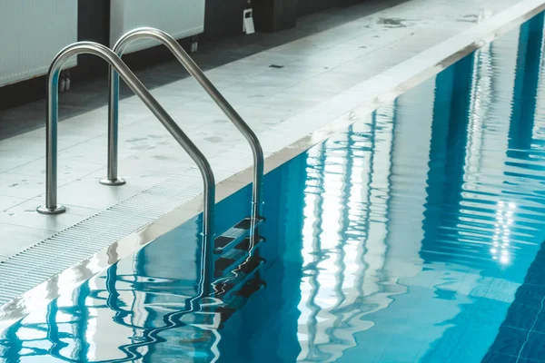 a water pool with blue transparent clear water, on which bright sunlight shines. Water lanes in the swimming pool. indoor sports field for swimming.