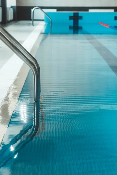 蓝色透明清澈的水 明亮的阳光照射在上面的水池 游泳池里的水路 游泳室内运动场 — 图库照片
