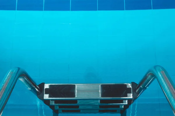 蓝色透明清澈的水 明亮的阳光照射在上面的水池 游泳池里的水路 游泳室内运动场 — 图库照片