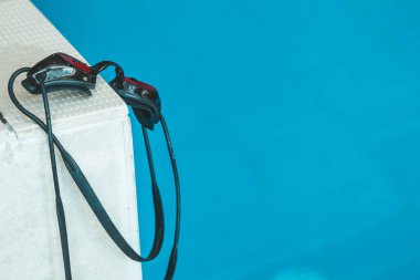 Yüzme gözlükleri yüzme havuzunun yanındaki korkuluktadır. kapalı yüzme spor ekipmanları.