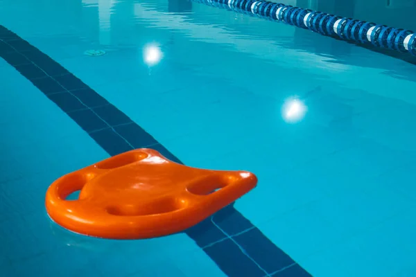 Een Plank Met Zwemgrepen Ligt Het Wateroppervlak Het Zwembad Zwemplank — Stockfoto