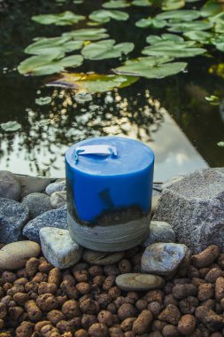 Ev yapımı çok renkli mumlar. Arka planda beton ve göl var. El yapımı dekor yakın plan. Renkli bir küp ve tavan arası mumunun ayrıntıları.