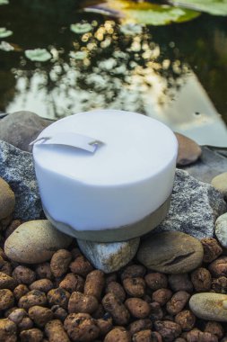 Ev yapımı çok renkli mumlar. Arka planda beton ve göl var. El yapımı dekor yakın plan. Renkli bir küp ve tavan arası mumunun ayrıntıları.