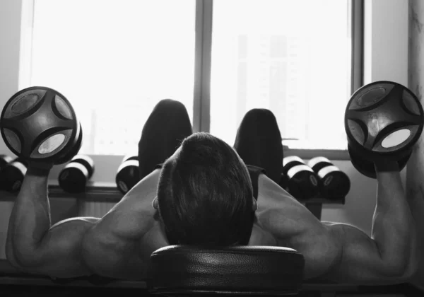 筋肉の大きい男がジムで重量挙げをしています ポンプ式アスリートは 重い重量シミュレータ上のスポーツのために入る スポーツ演習 — ストック写真