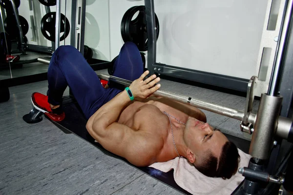 남자는 체육관에서 역도를 있습니다 운동화 선수가 무거운 시뮬레이터를 이용해 운동을 — 스톡 사진