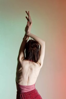 Renkli arka plan, neon ışıklar, stüdyo çekimi. Güzel elbiseli, zarif esmer bir kadının portresi. Çıplak olarak. Dikey fotoğraf, metin için yer