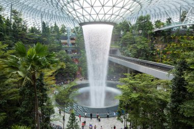 Singapur - 21 Ekim 2019: Dünyanın en yüksek kapalı şelalesinin Singapur Uluslararası Havalimanı Jewel Changi Havalimanı 'ndaki teraslı ormanlarla çevrili genel manzarası.