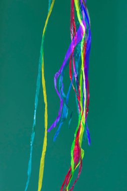 Soyut hareketli çizgilerin gökkuşakları, parlak renklerle, düz bir arkaplanda hafifçe süzülen buruşuk kumaşlar tarafından oluşturuldu.