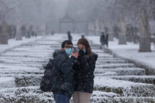スペインのマドリード 2021年1月7日 雪の日の真ん中 マドリードのBuen Retiro公園で 極低温の波のために 若いカップルが携帯電話で自撮りをします — ストック写真