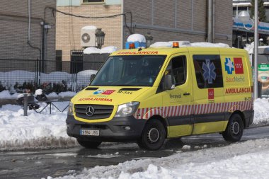 Madrid, İspanya - 10 Ocak 2021: Filomena kutup soğuk cephesi nedeniyle kar yağışlı bir günde hastane genel üniversitesi Gregorio Maranon 'a bir ambulans geldi..