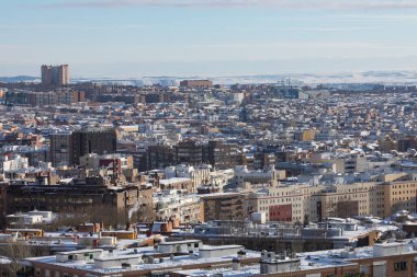 Madrid, Spain - January 10, 2021: Aerial view of Madrid, towards the Vallecas area, covered with snow, on a snowy day, due to the Filomena polar cold front. clipart