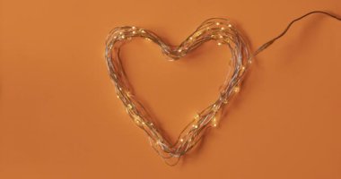 Lider ışıkların kalbi, aşıklar için mükemmel, romantik ve sevgi dolu bir Sevgililer Günü için. Sade turuncu arka planlı dur hareketi tekniğiyle animasyon.