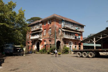 Yangon, Myanmar - 19 Aralık 2019: Eski bir apartman bloğu, hala ikamet ediyor, ve kötü durumda, Yangon şehir merkezinde, işlek Strand Yolu yakınında..