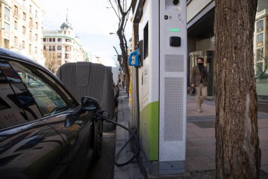 Madrid, İspanya - 07 Şubat 2021: Madrid şehir merkezinde elektrikli ve hibrit arabaların şarj noktası. Elektrik ve sürdürülebilirlik için kamu yollarındaki şarj istasyonu.