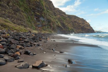 İspanya 'nın Kanarya Adaları, La Palma adasının kuzeydoğusundaki Nogales plajında devasa siyah volkanik kaya kayalıkları olan heybetli bir manzara..