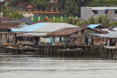 Sorong, Endonezya - 18 Ekim 2019: Waisai 'nin Sorong feribotuna vardığı yere yakın, Batı Papua' nın Sorong kasabasındaki deniz kenarındaki mütevazı küçük evlerin silüeti.
