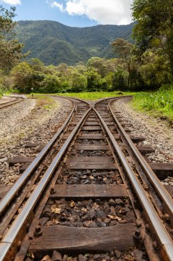 Eski ve paslı tren raylarını geçmek, Urubamba Nehri 'nin yanındaki rayları değiştirmek, Santa Teresa kasabasına doğru gitmek, Aguas Calientes' ten, Machu Picchu yakınlarında, Amazon bulut ormanı ile çevrili.
