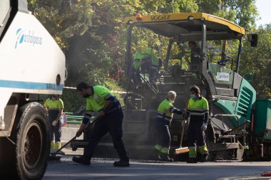 Madrid, İspanya - 5 Mayıs 2021: Madrid şehir merkezindeki caddelerin bakım, rehabilitasyonu ve kaldırımları, asfalt bitirici ve diğer makine ve araçlar kullanılarak.