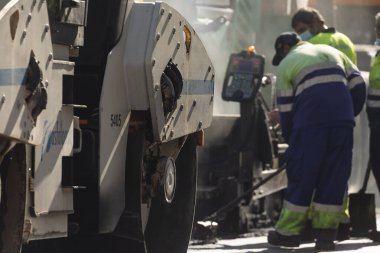 Madrid, İspanya - 5 Mayıs 2021: Madrid şehir merkezindeki caddelerin bakım, rehabilitasyonu ve kaldırımları, asfalt bitirici ve diğer makine ve araçlar kullanılarak.