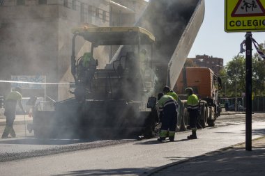 Madrid, İspanya - 5 Mayıs 2021: Madrid şehir merkezindeki caddelerin bakım, rehabilitasyonu ve kaldırımları, asfalt bitirici ve diğer makine ve araçlar kullanılarak.