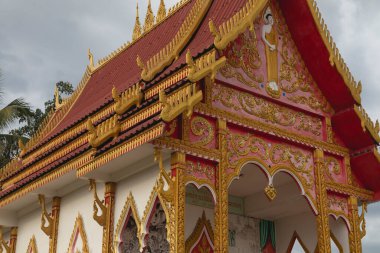 Cemaat ve büyüleyici Budist tapınağı Wat Phone Pang, gün batımında, Muang, Laos, Pakse 'den çok uzak olmayan Mekong nehrinin kıyısında, altın motifler ve Buda' nın kabartmaları ile süslenmiş..