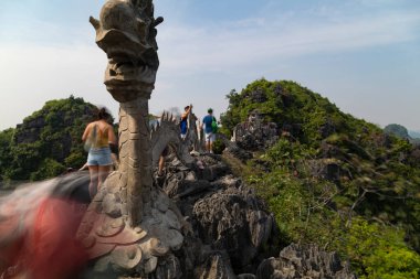 Hang Mua, Vietnam - 11 Kasım 2019: Hang Mua 'nın tepesindeki taş ejderha heykeli, Ninh Binh, Vietnam yakınlarındaki turistler tarafından ziyaret edilen ünlü dağ ve türbe