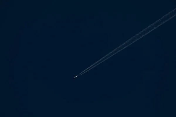 White Passenger Plane Flies Distance Dark Blue Sky Leaving Trail — Stock Photo, Image