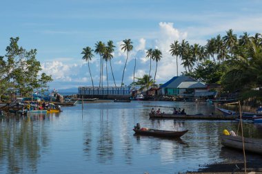 Waisai, Endonezya - 17 Ekim 2019: Waisai 'nin hemen dışında demirlemiş palmiye ağaçları ve tekneleri olan deniz manzarası, Batı Papua