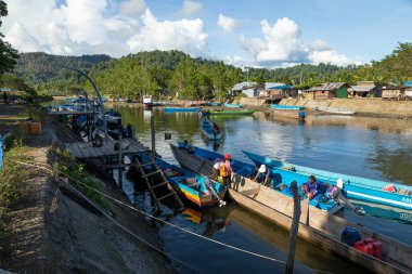 Waisai, Endonezya - 17 Ekim 2019: Bir geziden sonra bir grup insan Waisai dışındaki bir rıhtımda gemiden tekneye atlıyor.