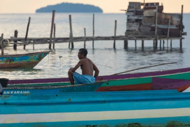 Yenbeser, Endonezya - 14 Ekim 2019: Bir adam tekneleri sabah Gam Adası, Raja Ampat yakınlarında balık tutmaya hazırlıyor
