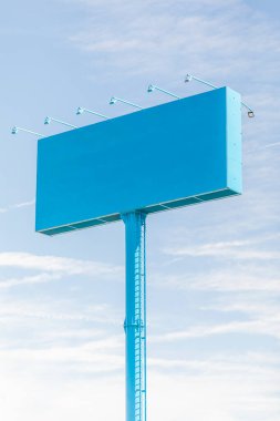 Mockup of blue giant billboard at gas station and service station near a highway, in a sunny day