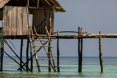 Sudaki ilkel bir kulübe, kütüklerle destekleniyor, Togian Adaları, Sulawesi, Endonezya 'nın balıkçıları ve sakinleri tarafından barınak olarak kullanılıyor.